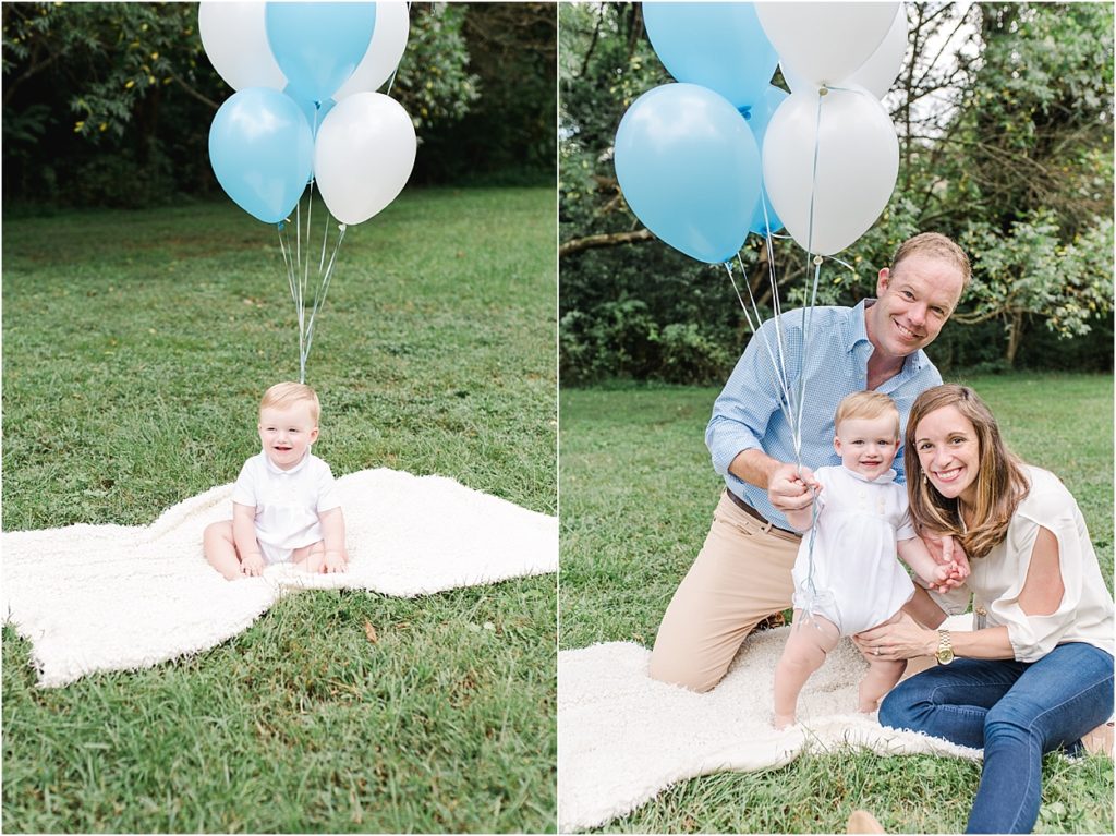 one year baby boy in park with blue and white balloons