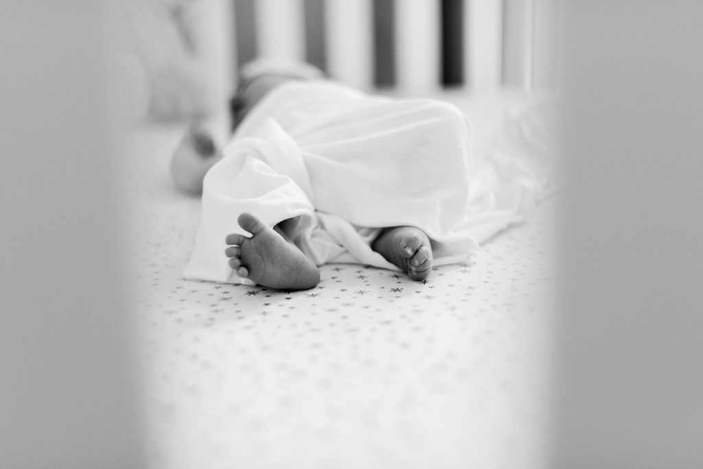 newborn baby girl toes in crib