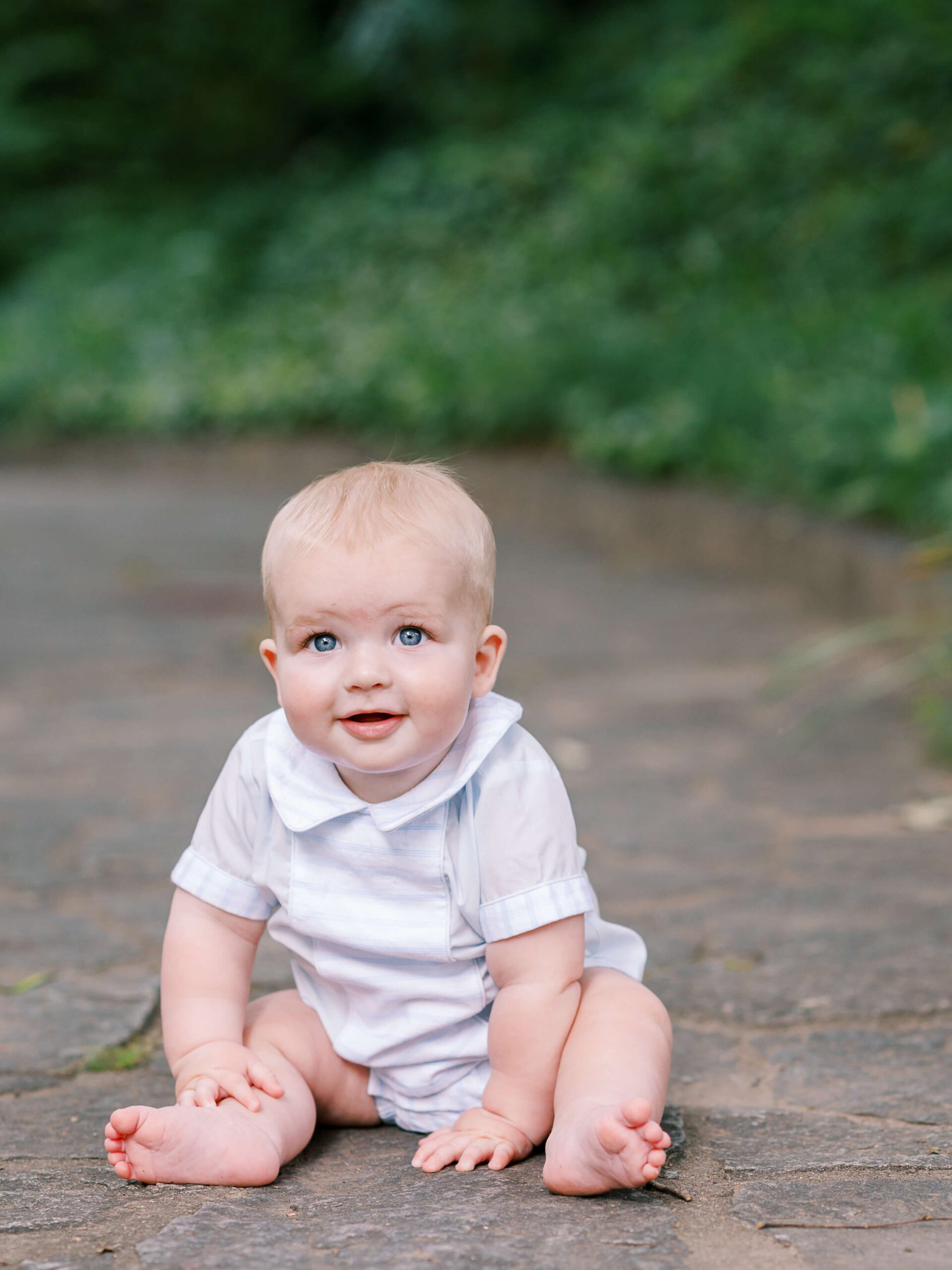 baby boy sitting on stone path