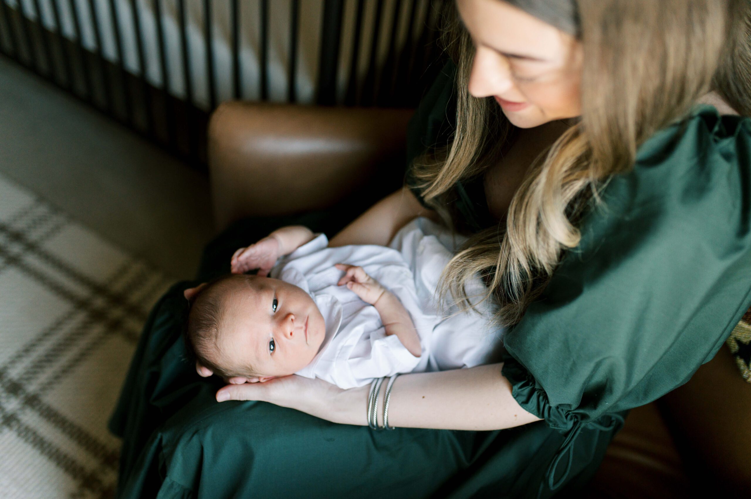 mother holding newborn baby in chair