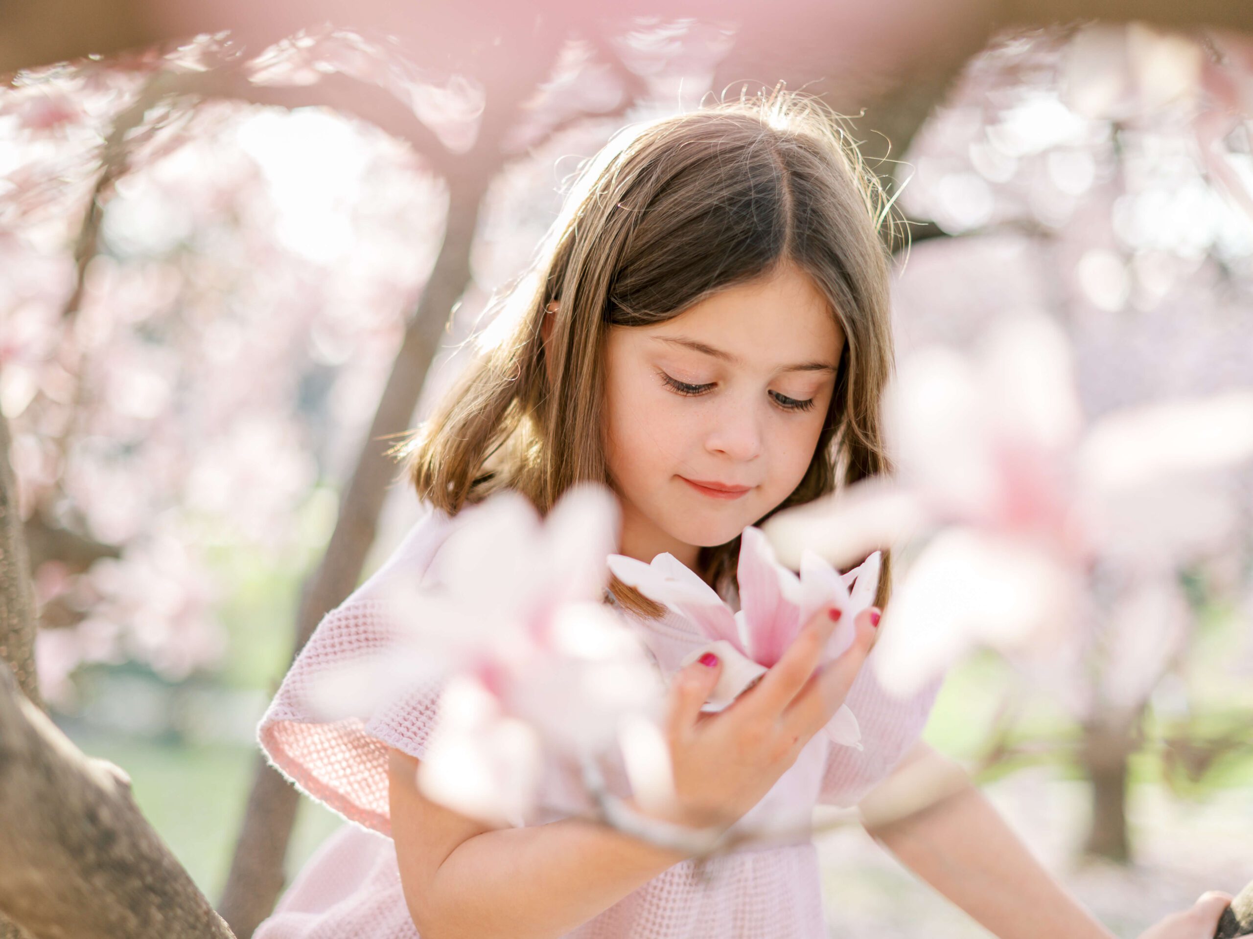 girl smelling magnolia flower